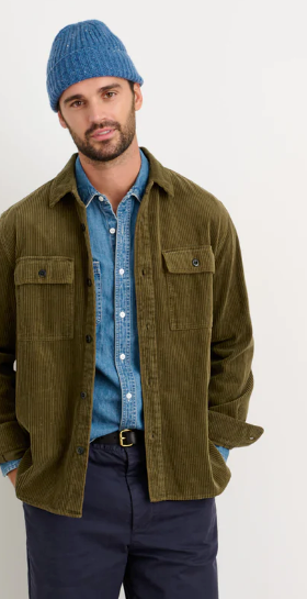 A man wearing a Alex Mill oliver green button up with a blue beanie and navy blue pants
