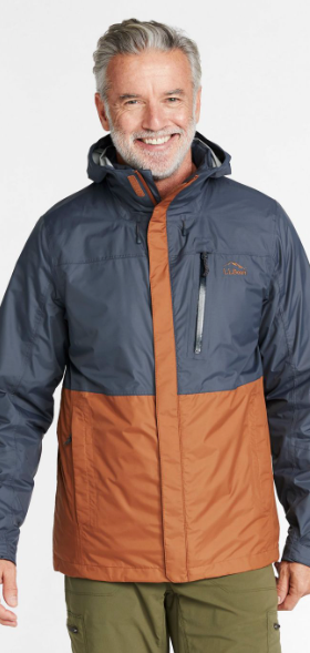 A man wearing a brown and navy blue LL Bean winter jacket and olive green pants