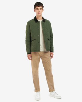 A man wearing a Barbour green jacket, a cream t-shirt and brown pants