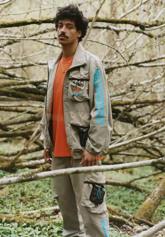 A man in the woods wearing an Adidas Palace collab outfit