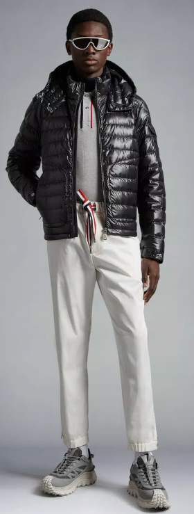 A man wearing a futuristic Moncler outfit featuring the patented puffy black jacket