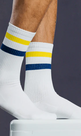 A close up of a Pair of Thieves white socks with a yellow and blue stripe