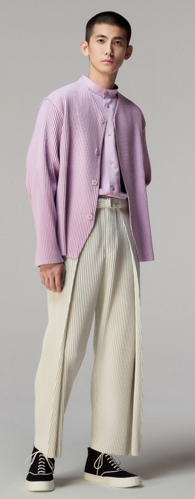 A man wearing an Issey Myake pink cardigan with beige slacks