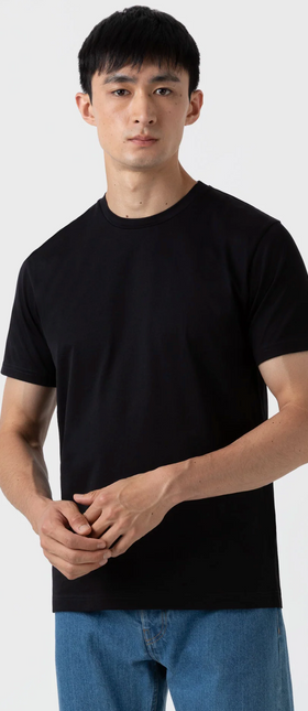 A man wearing a black Sunspel t-shirt with jeans
