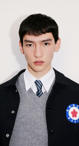 A young man wearing a school uniform with a Kenzo jacket