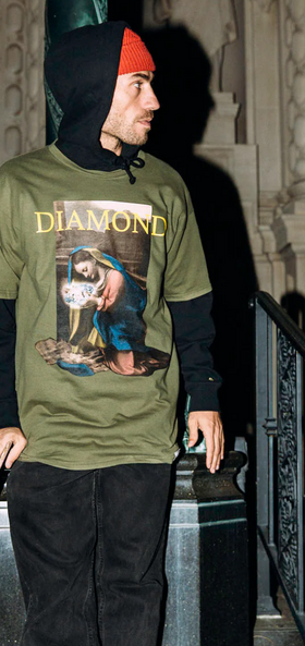 A man wearing a graphic Diamond Supply Co. t-shirt with a skateboard in hand