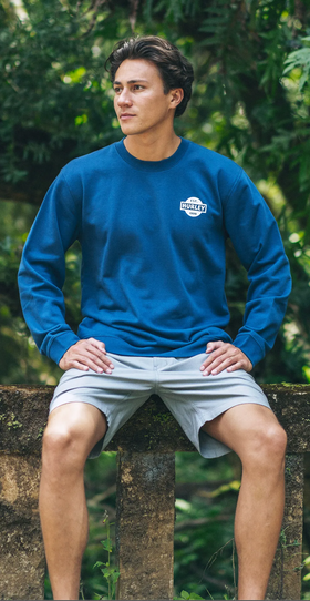 A man wearing a Hurley long-sleeve blue short and board shorts
