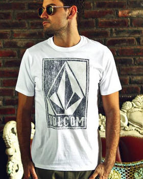 A man wearing a Volcom logo icon t-shirt in white and sunglasses