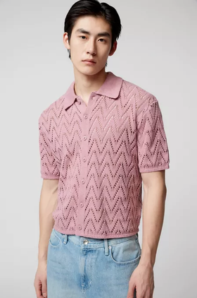A man wearing a trendy Urban Outfitters pink collared shirt and denim pants