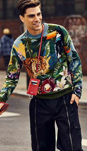 A man wearing a Dolce & Gabbana outfit featuring a tiger print sweater