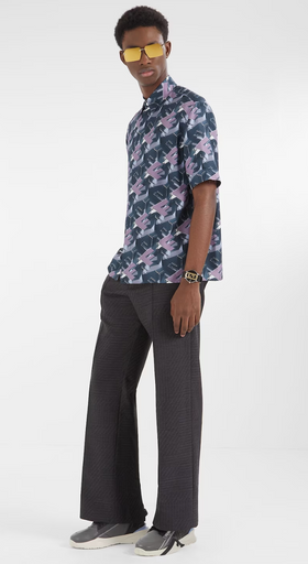 A man wearing a designer Fendi logo t-shirt and black bell-bottomed pants