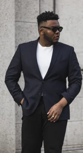 A man wearing a black Kenneth Cole suit with sunglasses