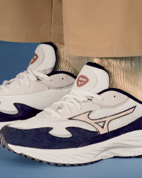 A man wearing a white and navy blue Mizuno runners