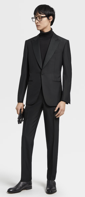 A man wearing an all black Zegna suit with a black turtleneck underneath