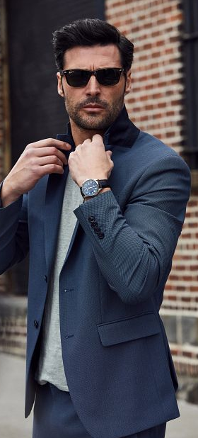 A man wearing a Bulova watch and a suit with sunglasses