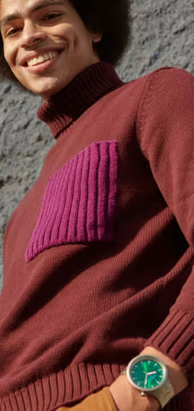 A man wearing a silver Swatch and a turtle-neck long-sleeve