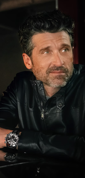 A man wearing a TAG Heuer watch with a black jacket