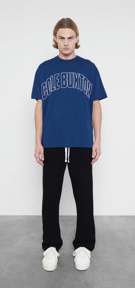 A man wearing Cole Buxton varsity arch outline navy t-shirt