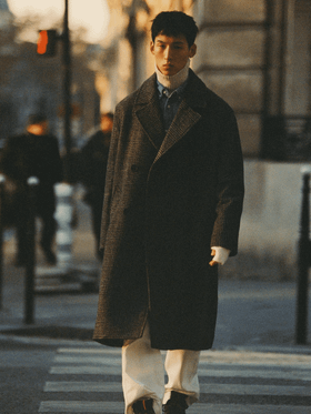 A man walking on the street wearing a Zara outfit featuring a brown jacket and beige turtleneck